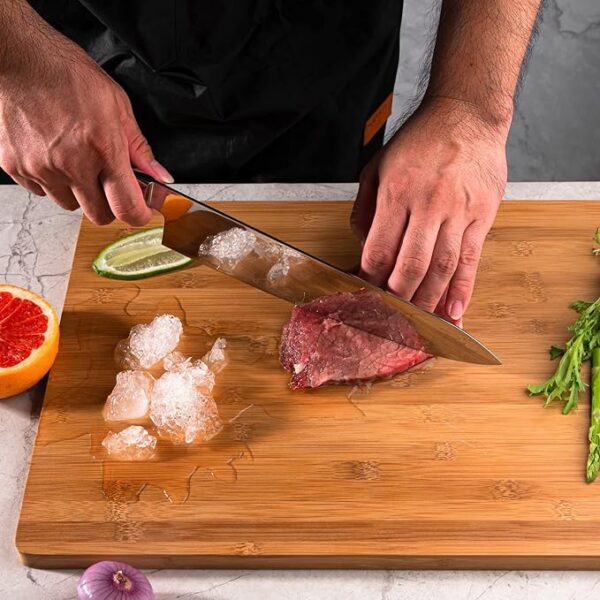 A chef cutting eat with a japanese knife on a cutting board