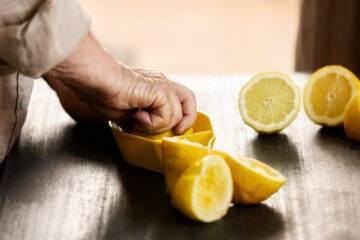 old person pressing lemons to make lemon juice