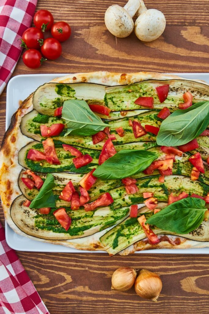 Delicious vegetable pizza with fresh basil, tomatoes, and eggplant, perfect for a healthy meal.