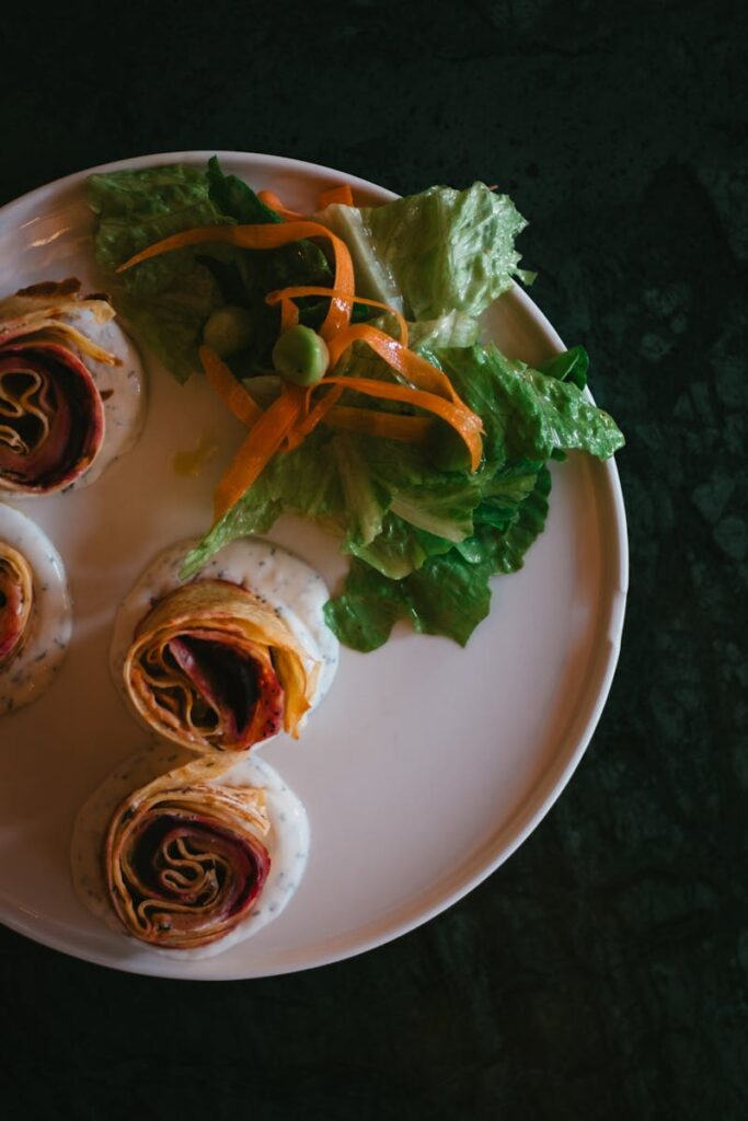 Appetizing wraps served with fresh salad on a white plate, perfect for a healthy meal.